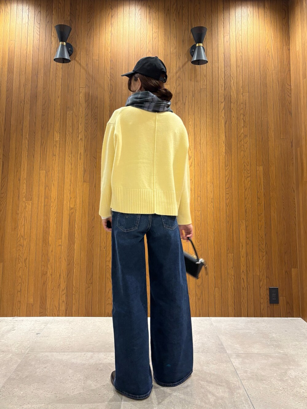 グレー系のその他アウター、イエロー系のニット/セーター、ブルー系のデニムパンツを着用したレディースの冬コーディネートの8枚目の写真