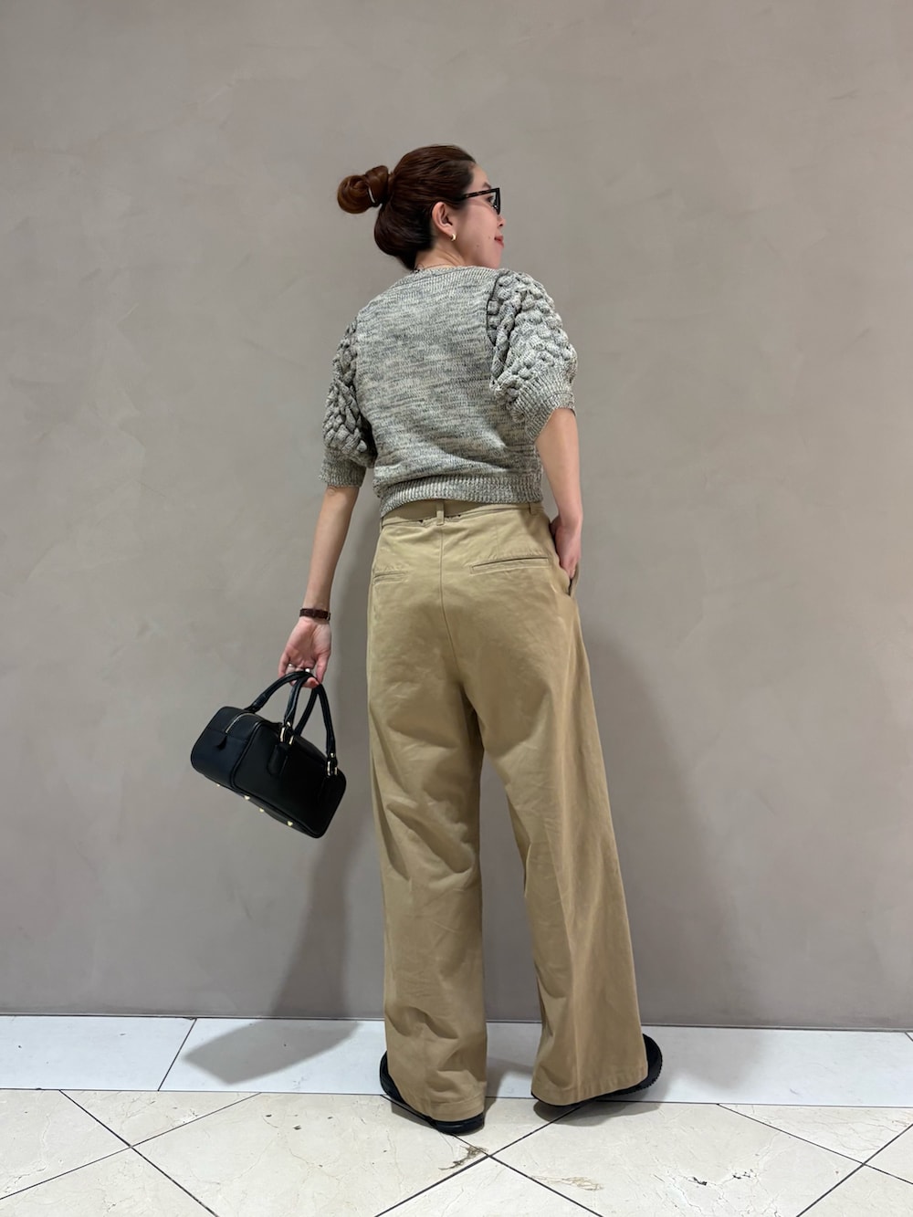 ベージュ系のその他パンツ、ブラック系のハンドバッグ、ホワイト系のニット/セーターを着用したレディースの春コーディネートの3枚目の写真