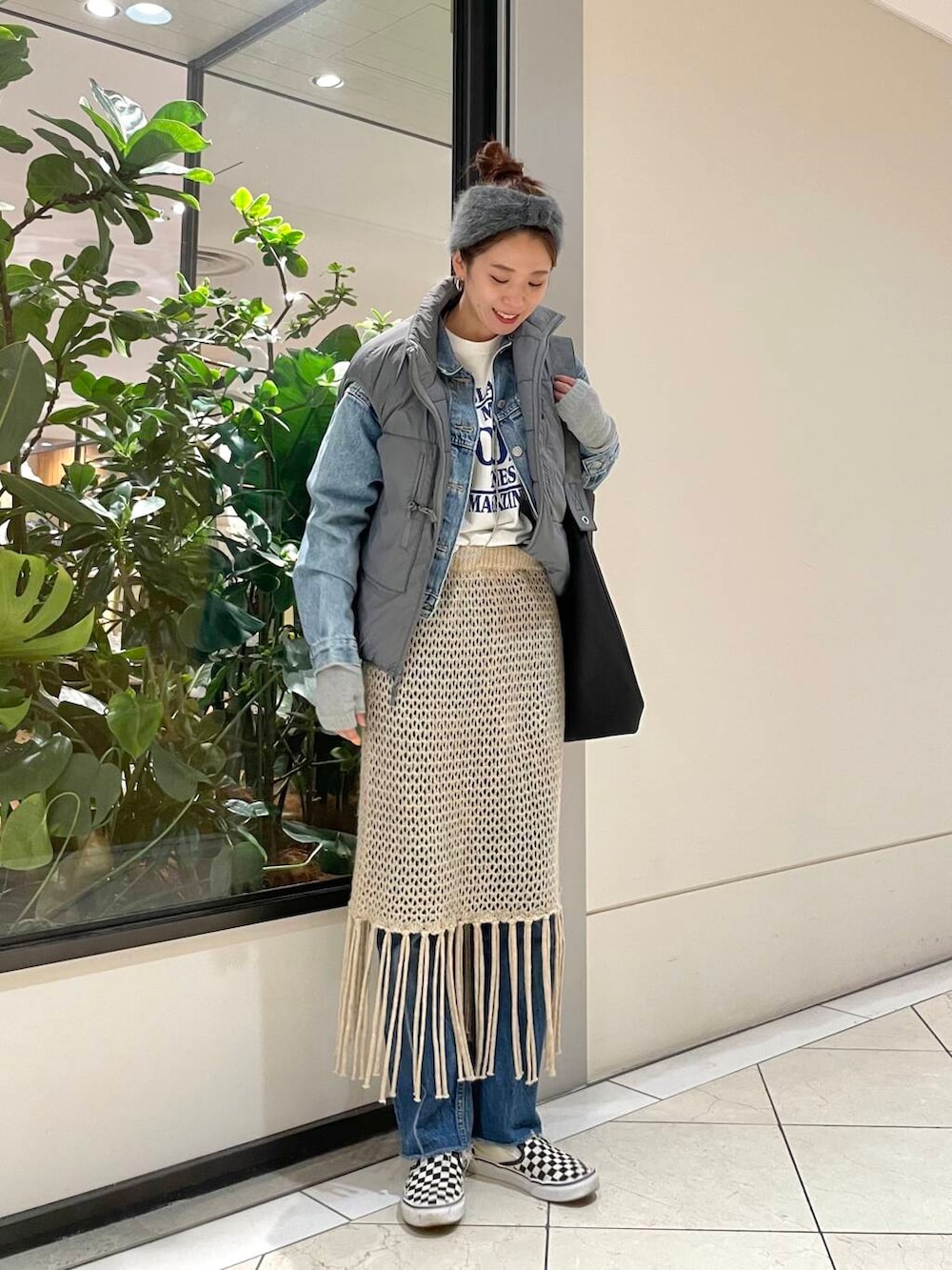 ベージュ系のスカート、ホワイト系のTシャツ/カットソー、グレー系のダウンベストを着用したレディースの冬コーディネートの5枚目の写真