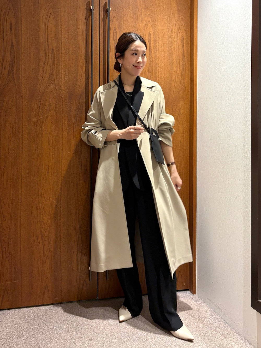 ベージュ系のトレンチコート、ブラック系のその他パンツ、ブラック系のその他アウターを着用したレディースの冬コーディネートの2枚目の写真