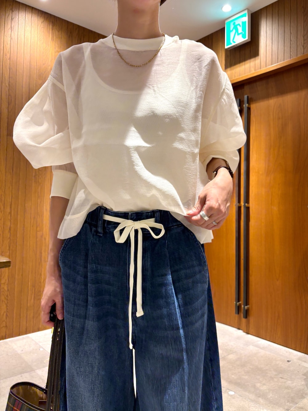 ブルー系のデニムパンツ、その他のショルダーバッグ、ホワイト系のTシャツ/カットソーを着用したレディースの夏コーディネートの7枚目の写真