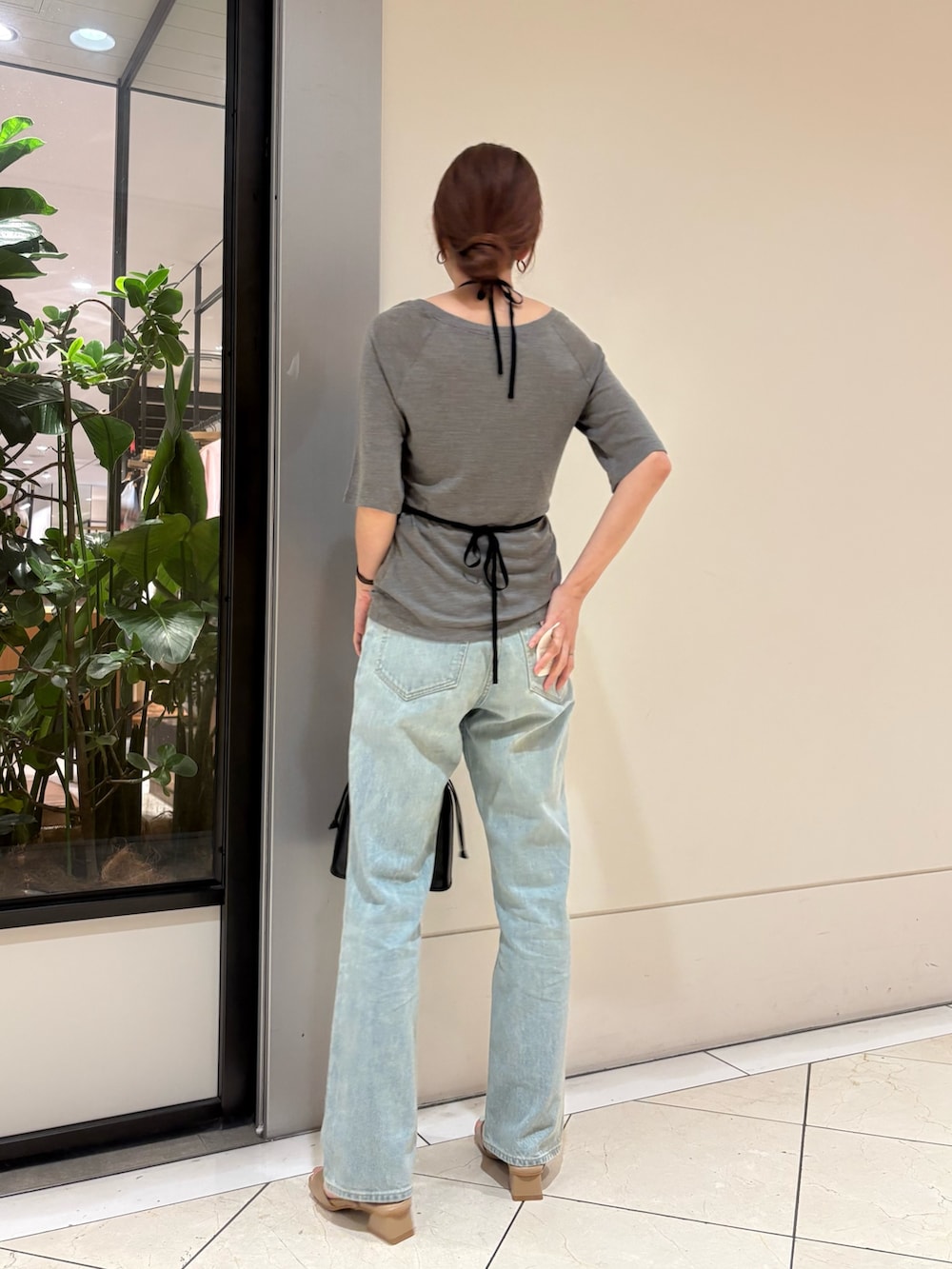 グレー系のTシャツ/カットソー、ブルー系のデニムパンツ、ベージュ系のサンダルを着用したレディースの夏コーディネートの3枚目の写真