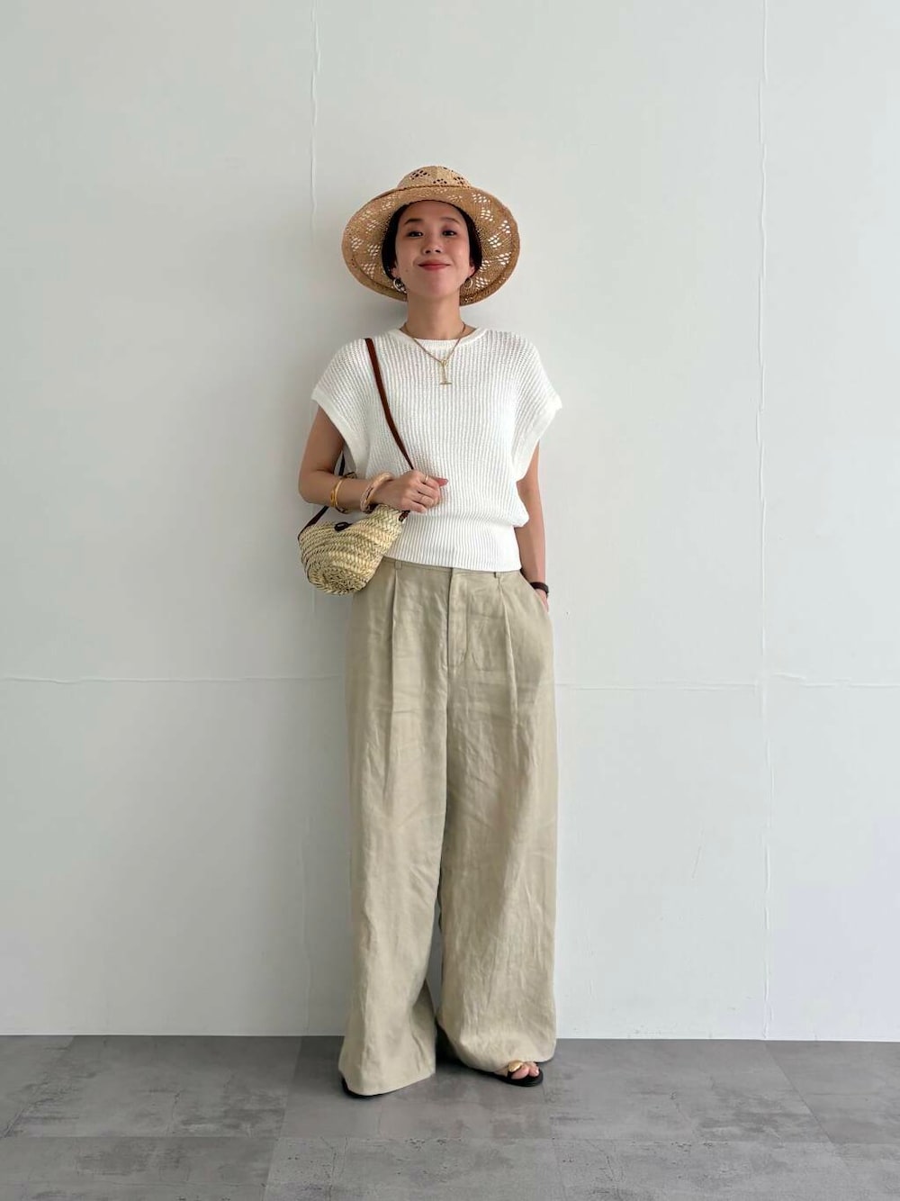 ベージュ系のその他パンツ、ホワイト系のベスト、ブラック系のサンダルを着用したレディースの夏コーディネートの4枚目の写真