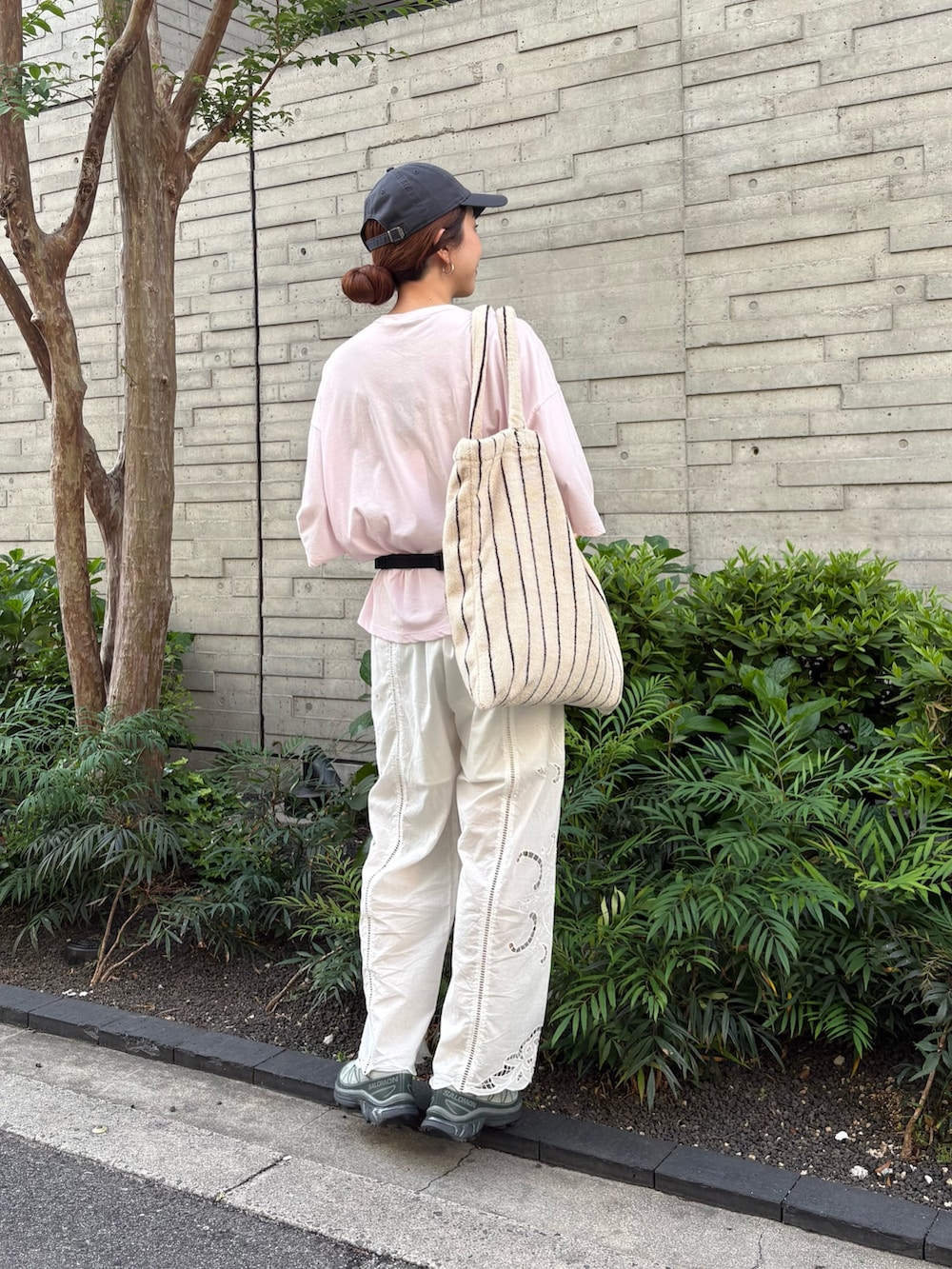 ピンク系のTシャツ/カットソー、グリーン系のスニーカー、ブラック系のボディバッグ/ウエストポーチを着用したレディースの春コーディネートの3枚目の写真