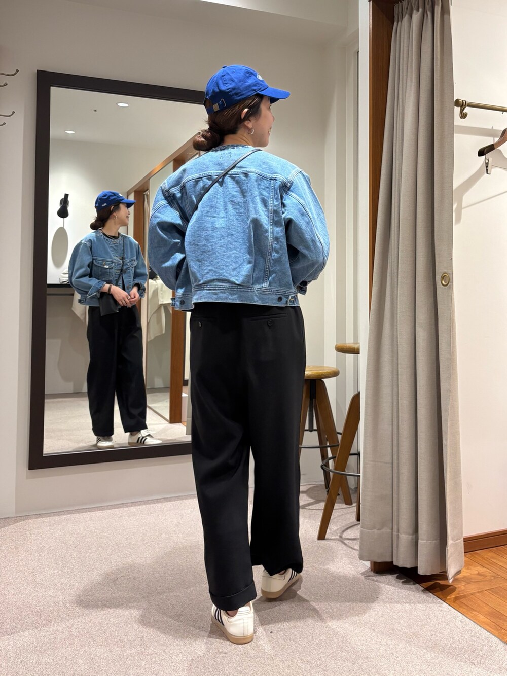 ブルー系のデニムジャケット、ブラック系のその他パンツ、ホワイト系のスニーカーを着用したレディースの冬コーディネートの3枚目の写真