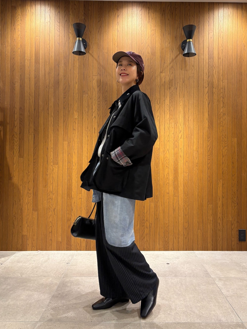 ブラック系のその他アウター、グレー系のその他パンツ、ブラック系のローファーを着用したレディースの秋コーディネートの2枚目の写真