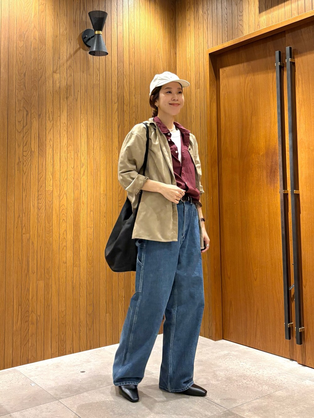 ブルー系のデニムパンツ、レッド系のシャツ/ブラウス、ブラック系のローファーを着用したレディースの夏コーディネートの5枚目の写真