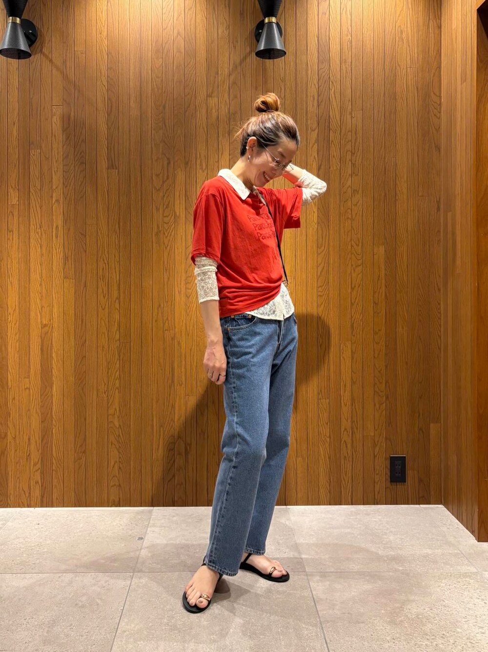 ブルー系のデニムパンツ、ブラック系のサンダル、レッド系のTシャツ/カットソーを着用したレディースの夏コーディネートの2枚目の写真