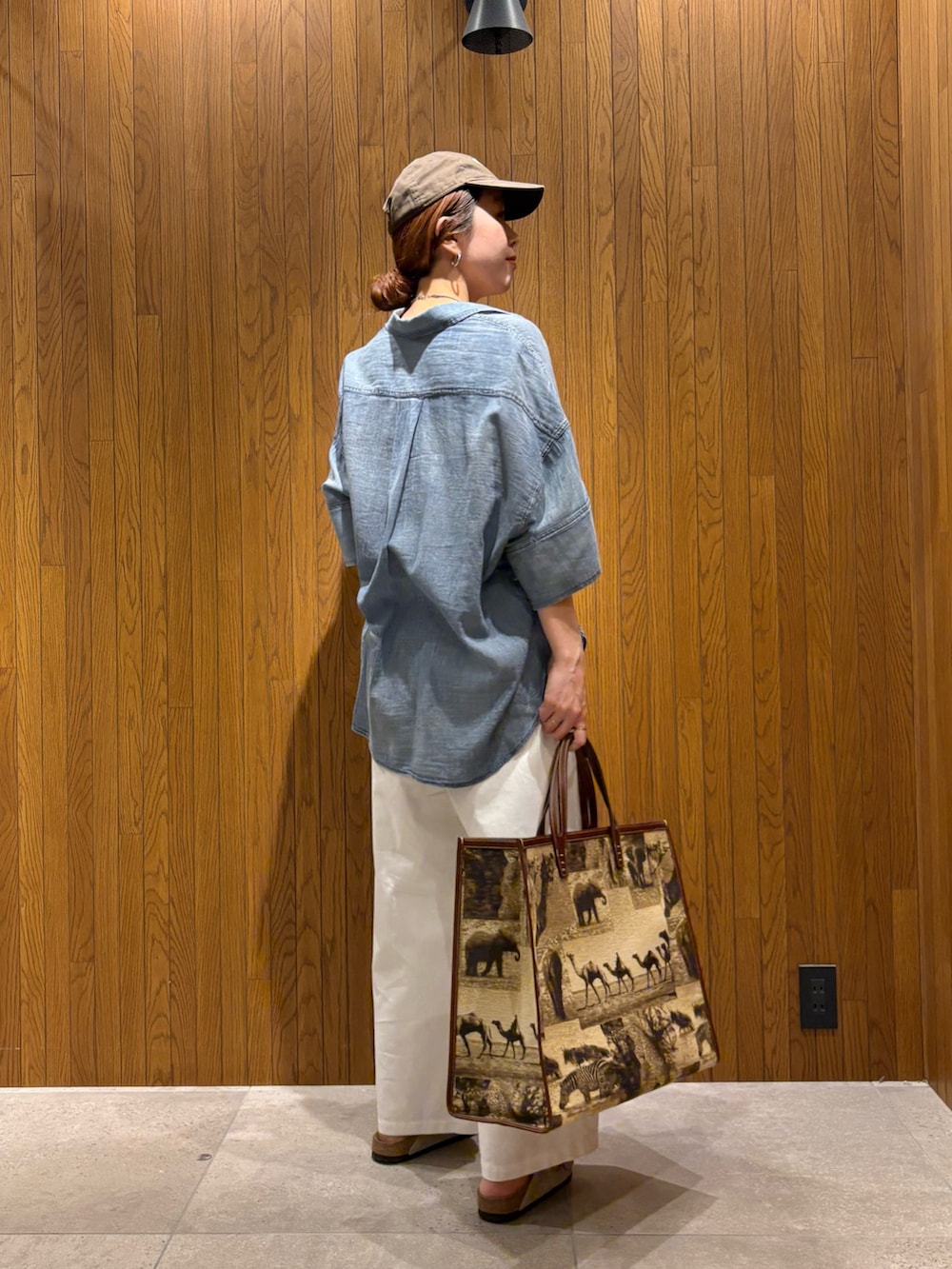 ブルー系のシャツ/ブラウス、ホワイト系のその他パンツ、ベージュ系のハンドバッグを着用したレディースの春コーディネートの2枚目の写真