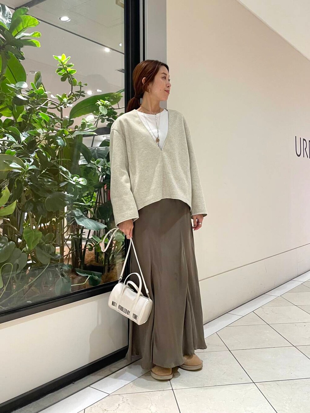 ホワイト系のボストンバッグ、グリーン系のスカート、ホワイト系のTシャツ/カットソーを着用したレディースの秋コーディネートの4枚目の写真