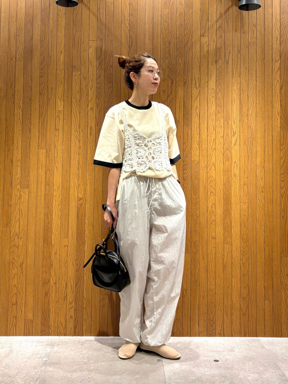 ホワイト系のニット/セーター、グレー系のその他パンツ、ブラック系のショルダーバッグを着用したレディースの夏コーディネートの2枚目の写真