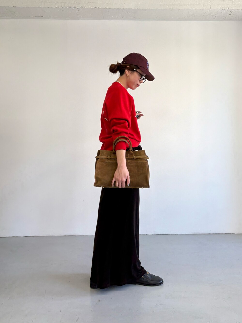 レッド系のスウェット、ブラウン系のトートバッグ、ブラック系のローファーを着用したレディースの秋コーディネートの4枚目の写真