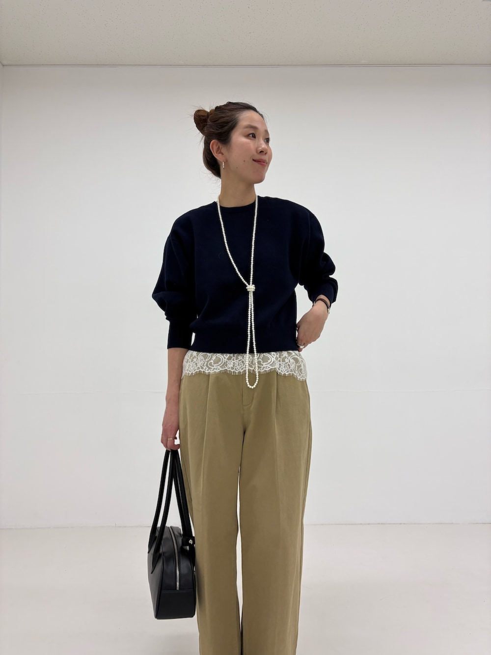 ブラック系のパンプス、ブルー系のニット/セーター、ベージュ系のその他パンツを着用したレディースの冬コーディネートの8枚目の写真