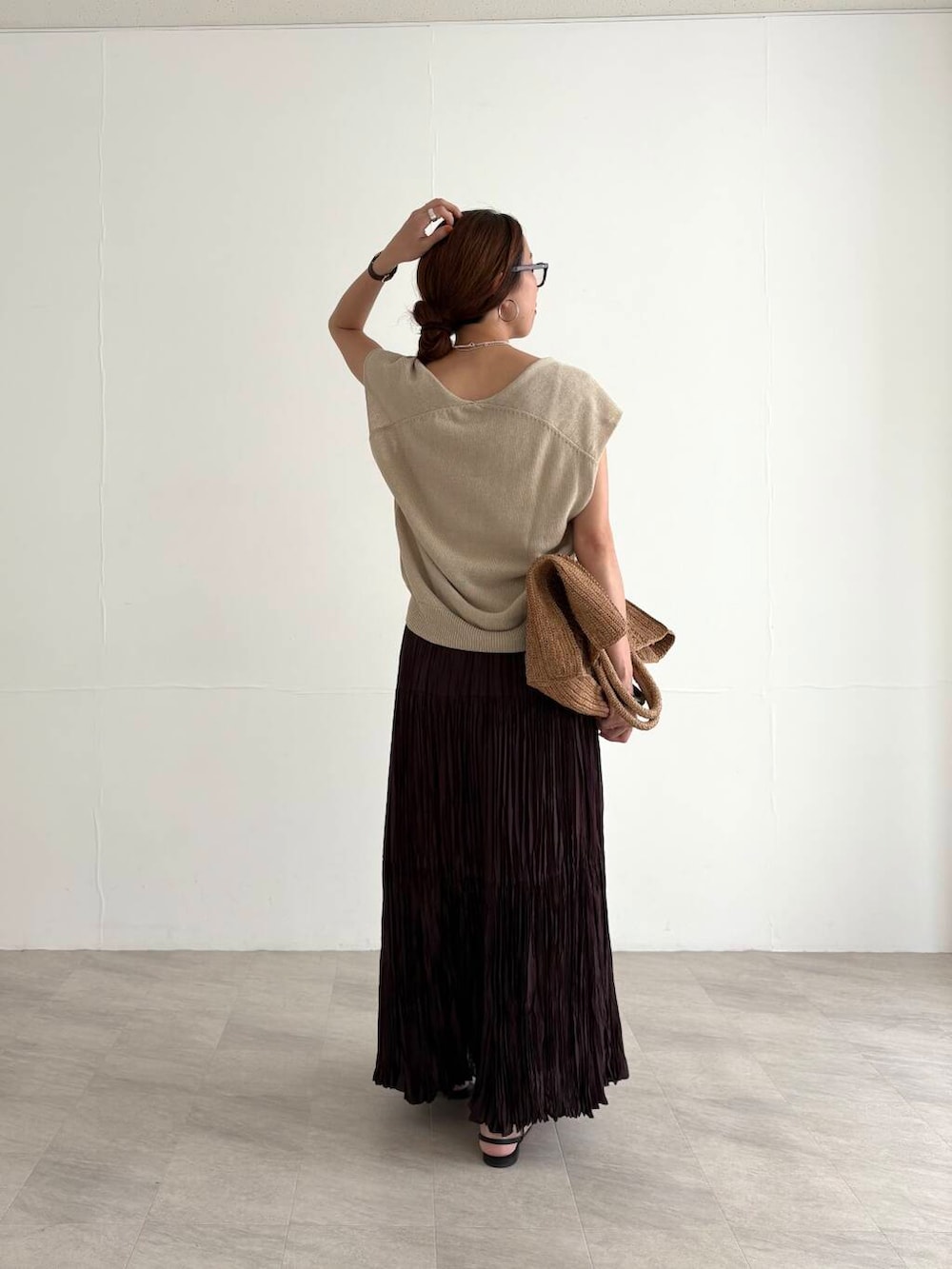 ホワイト系のキャミソール、ブラウン系のスカート、ベージュ系のベストを着用したレディースの夏コーディネートの3枚目の写真