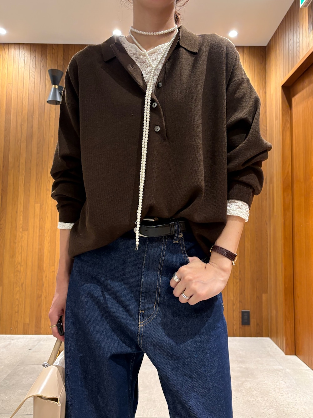 ブラウン系のニット/セーター、ホワイト系のTシャツ/カットソー、ブルー系のデニムパンツを着用したレディースの秋コーディネートの6枚目の写真