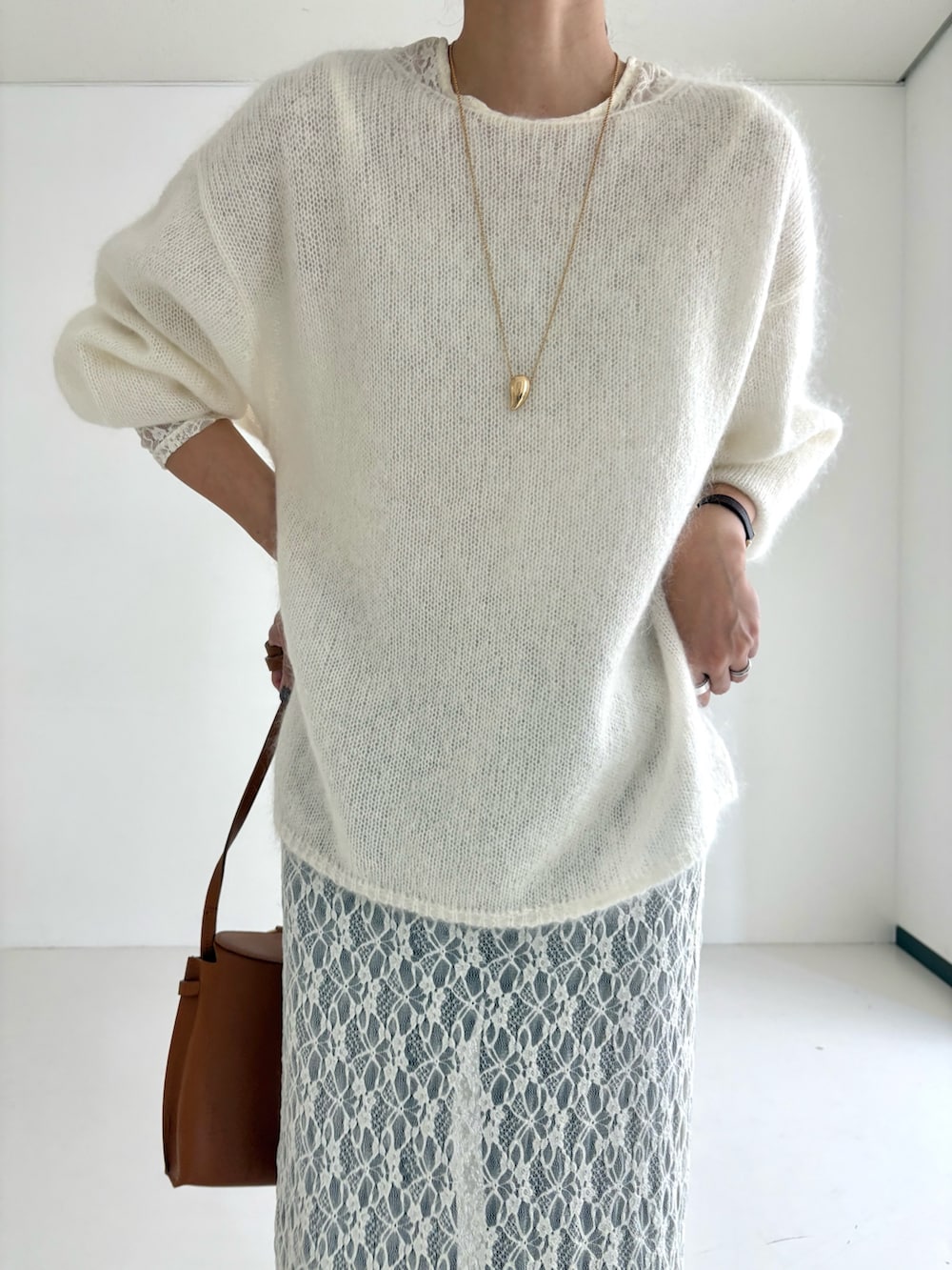 ホワイト系のニット/セーター、ホワイト系のワンピース、ブラック系のデニムパンツを着用したレディースの秋コーディネートの6枚目の写真