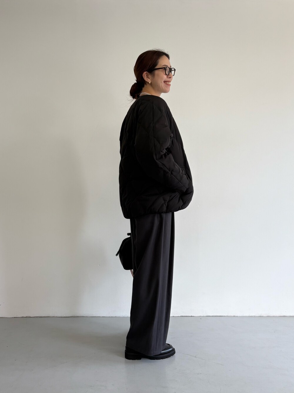 ブラック系のダウンジャケット/コート、グレー系のその他パンツ、ブラック系のローファーを着用したレディースの冬コーディネートの3枚目の写真