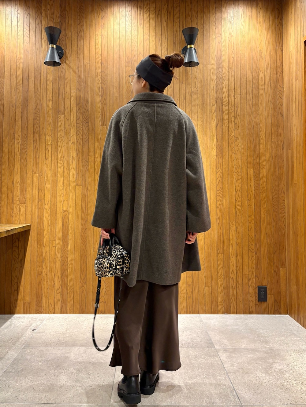 グリーン系のステンカラーコート、ブラウン系のスカート、その他のハンドバッグを着用したレディースの冬コーディネートの4枚目の写真