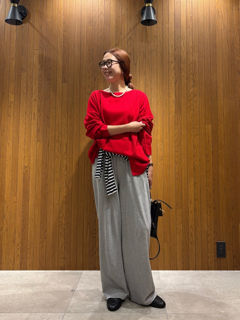 レッド系のニット/セーター、ブルー系のTシャツ/カットソー、グレー系のその他パンツを着用したレディースの秋コーディネートの5枚目の写真