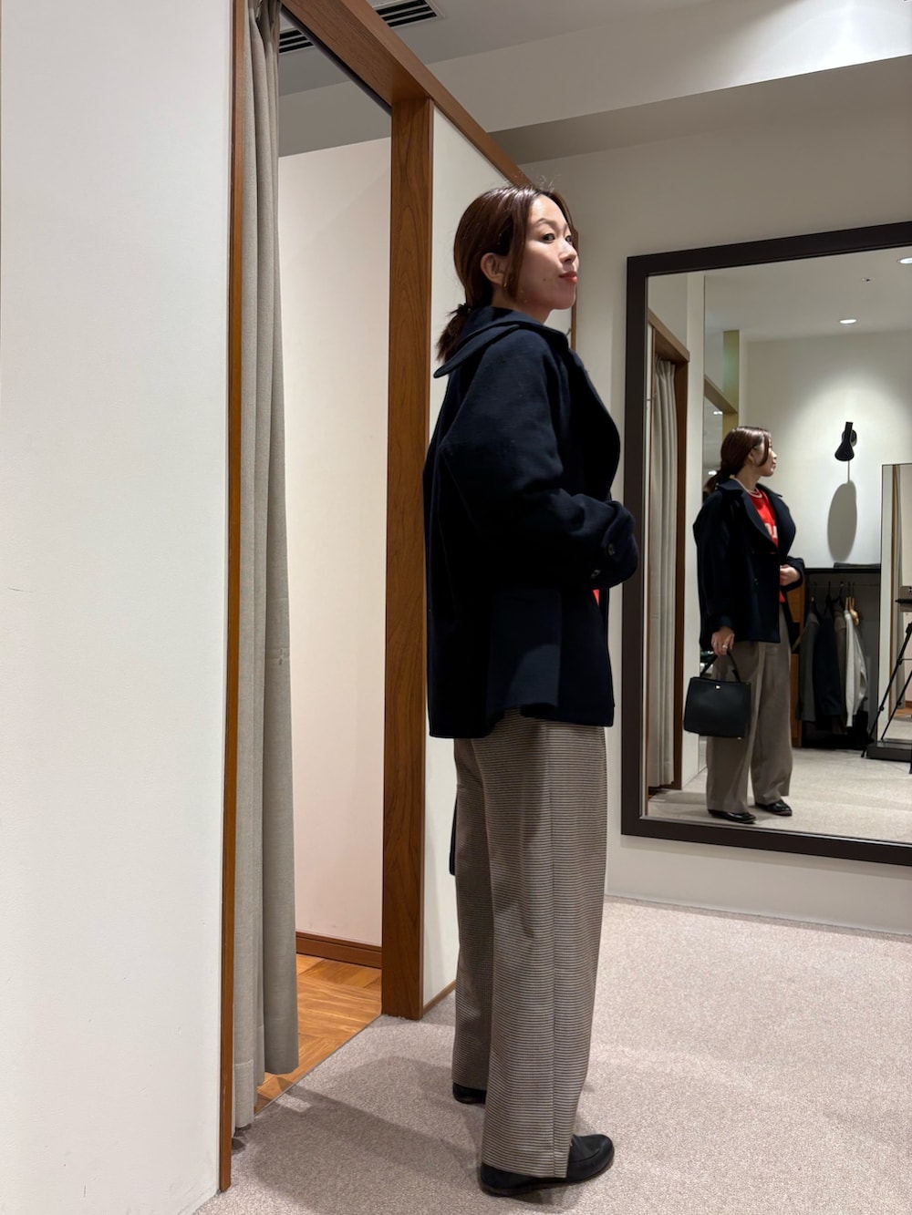 グレー系のピーコート、レッド系のスウェット、イエロー系のその他パンツを着用したレディースの秋コーディネートの2枚目の写真