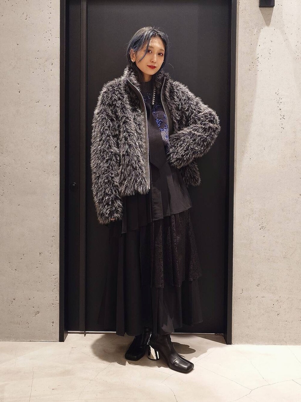 ブラック系のネクタイ、ブルー系のニット/セーター、ブラック系のブーツを着用したレディースの秋コーディネートの2枚目の写真