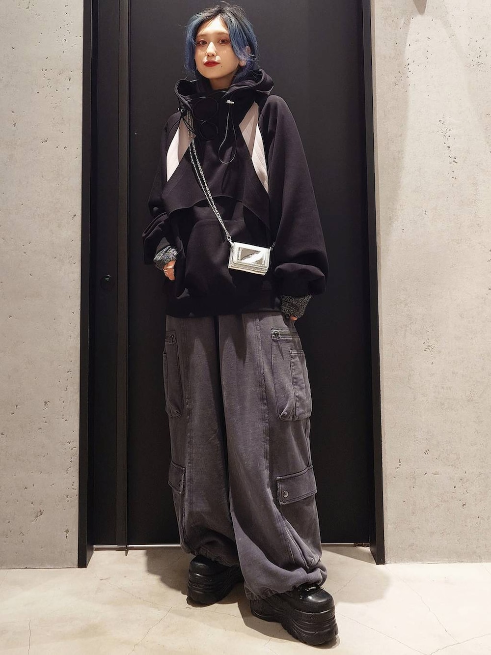 グレー系のTシャツ/カットソー、グレー系のカーゴパンツ、ブラック系のパーカーを着用したレディースの冬コーディネートの2枚目の写真