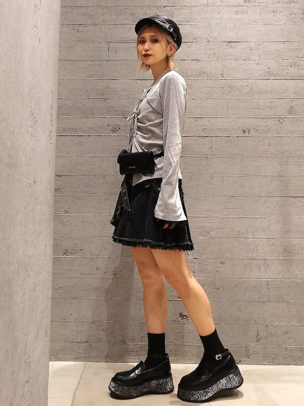 ブラック系のスカート、グレー系のTシャツ/カットソー、グレー系のローファーを着用したレディースの春コーディネートの2枚目の写真