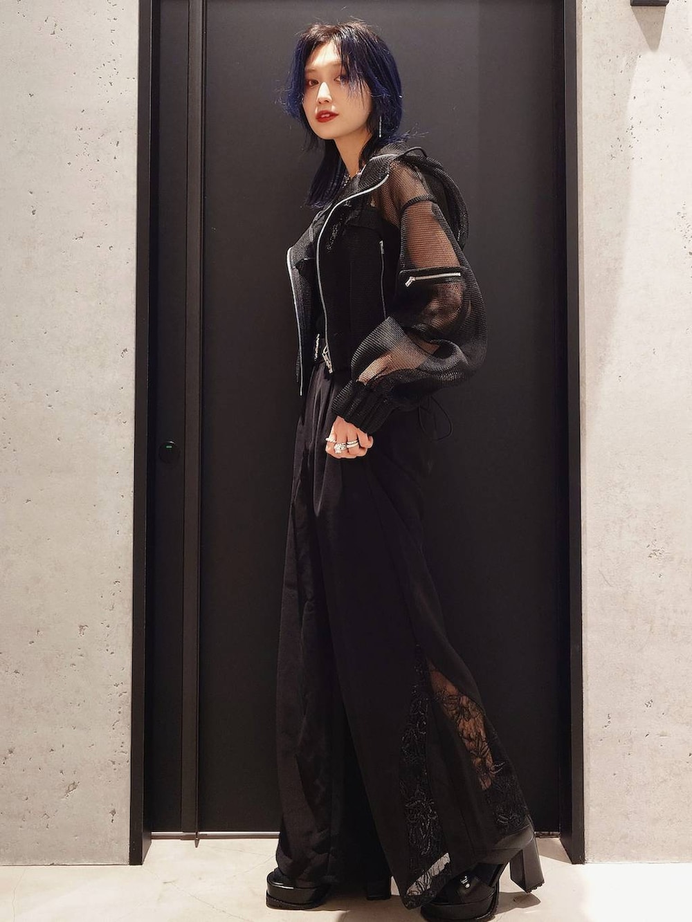 ブラック系のタンクトップ、ブラック系のブルゾン、ブラック系のブーツを着用したレディースの春コーディネートの2枚目の写真