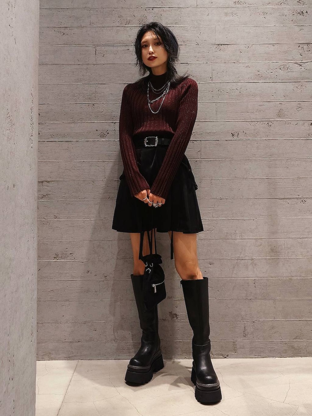 レッド系のニット/セーター、グレー系のチェスターコート、ブラック系のその他パンツを着用したレディースの秋コーディネートの3枚目の写真