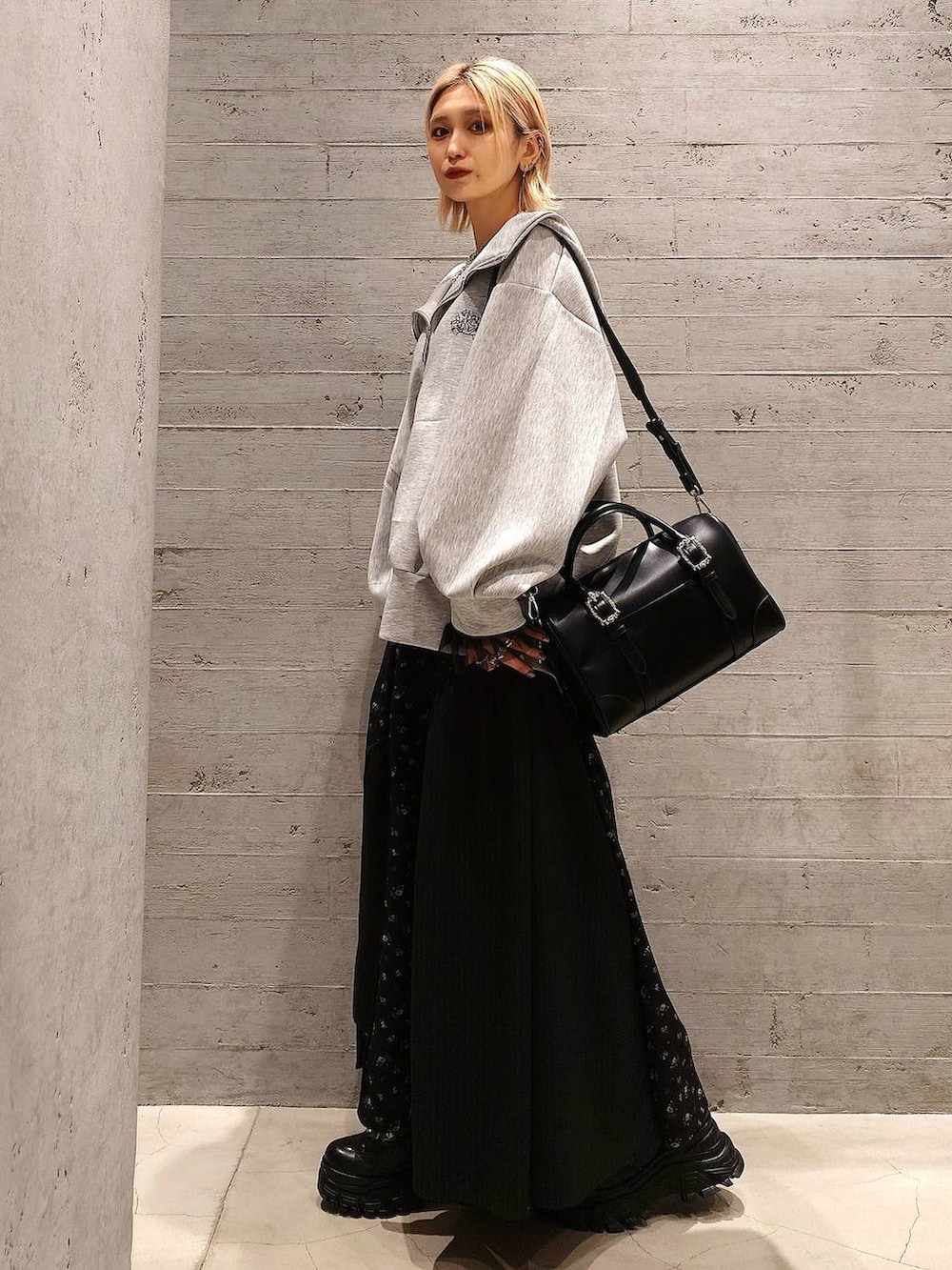 ブラック系のスニーカー、ブラック系のボストンバッグ、グレー系のパーカーを着用したレディースの春コーディネートの2枚目の写真