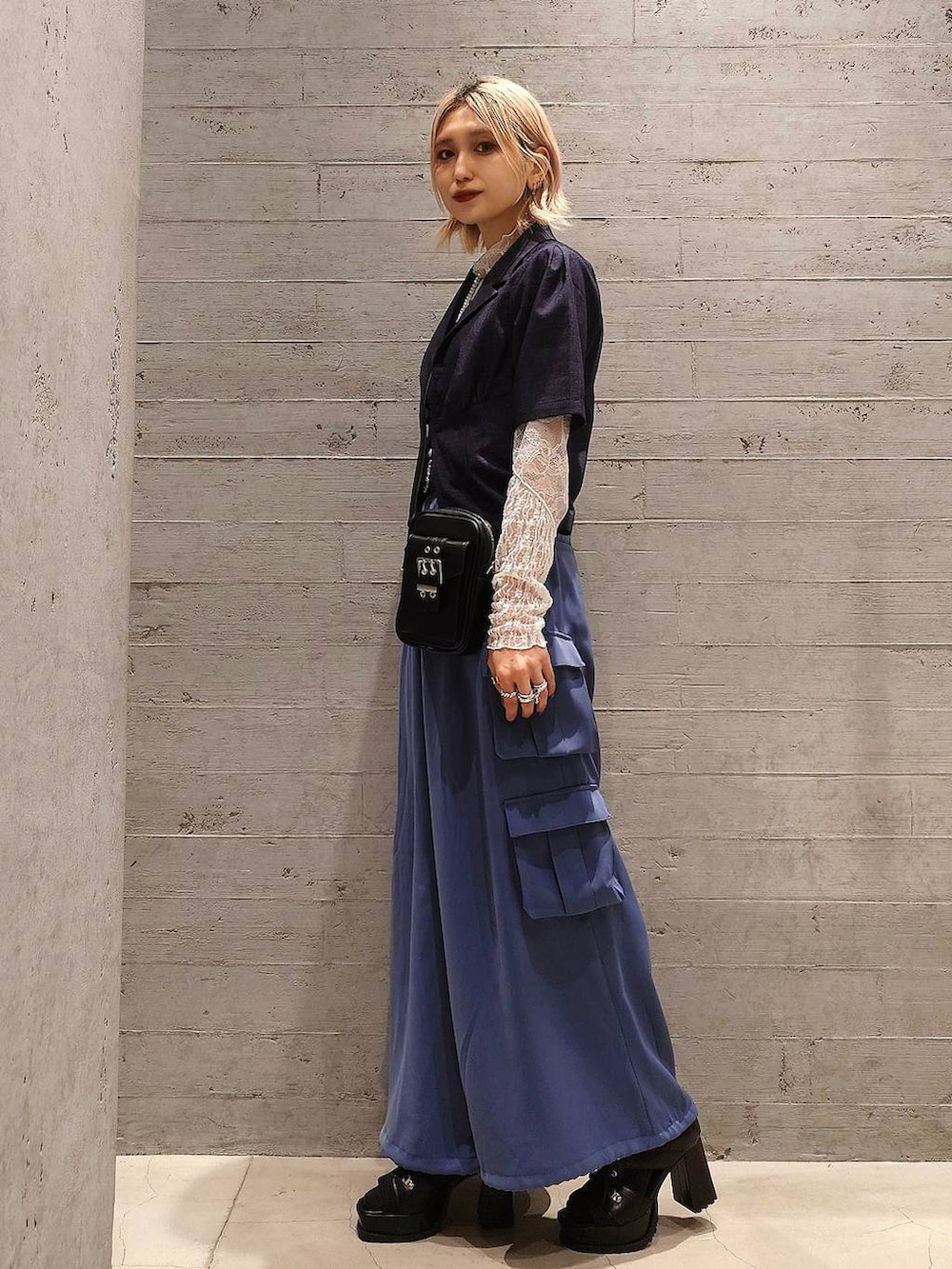 ブラック系のブーツ、ブルー系のカーゴパンツ、ホワイト系のTシャツ/カットソーを着用したレディースの春コーディネートの2枚目の写真