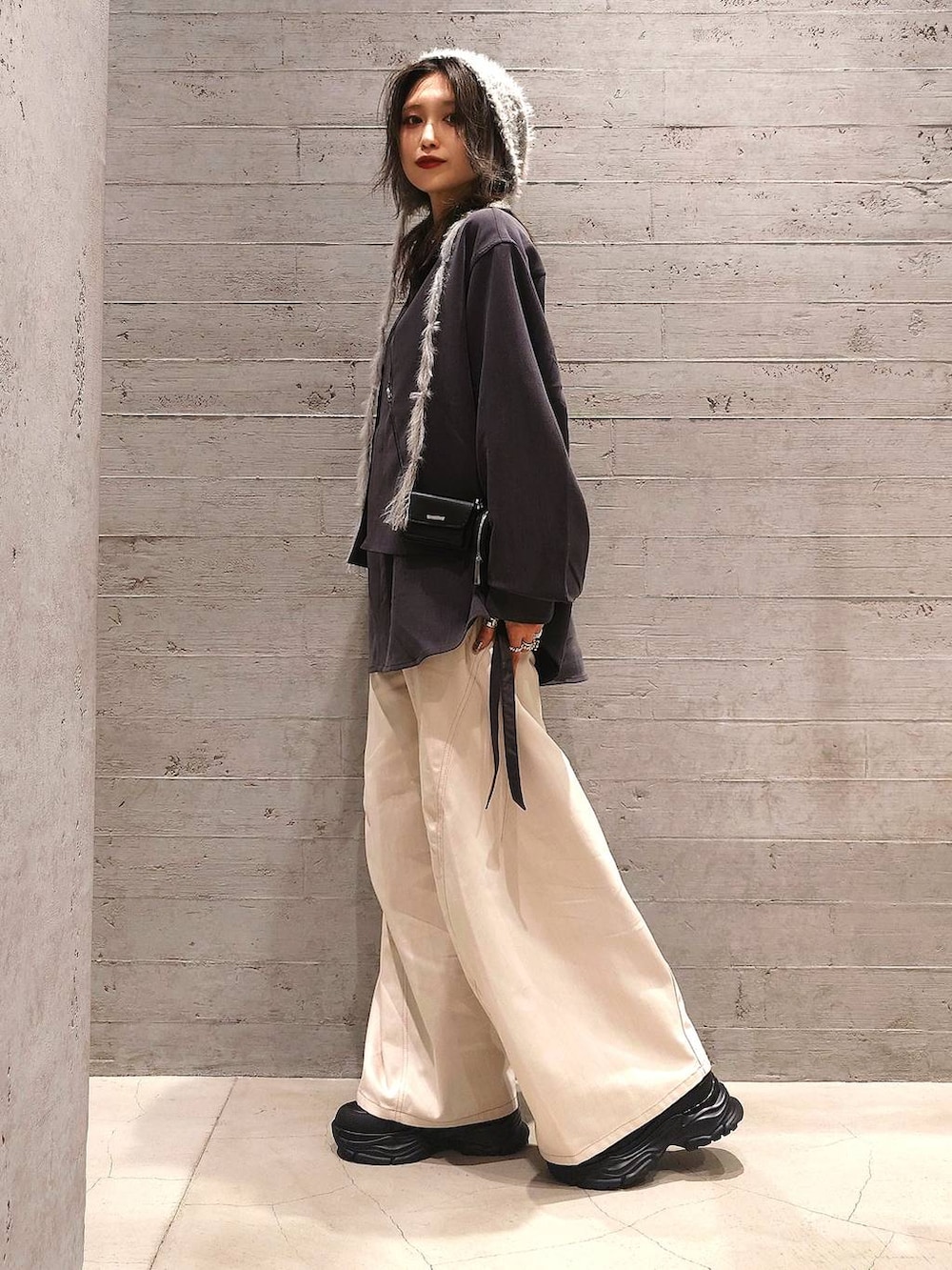 ホワイト系のデニムパンツ、グレー系のシャツ/ブラウス、ブラック系のブーツを着用したレディースの秋コーディネートの2枚目の写真