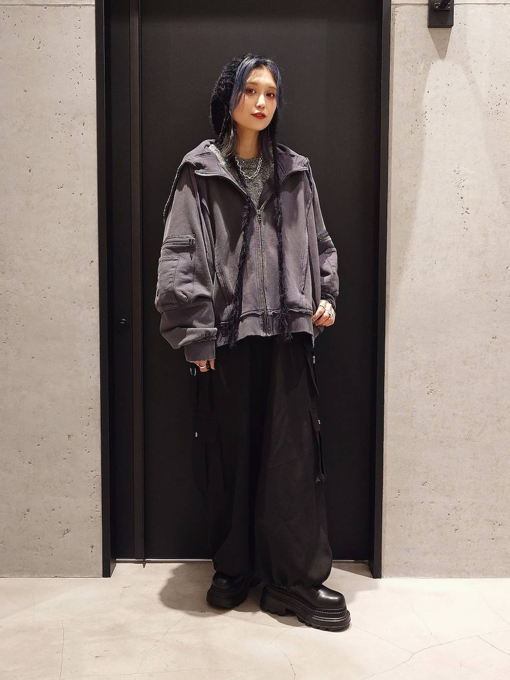 グレー系のパーカー、ブラック系のカーゴパンツ、グレー系のニット/セーターを着用したレディースの秋コーディネートの2枚目の写真