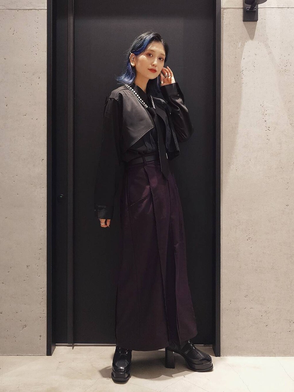 ブラック系のネクタイ、ブラック系のブーツ、レッド系のテーラードジャケットを着用したレディースの夏コーディネートの3枚目の写真