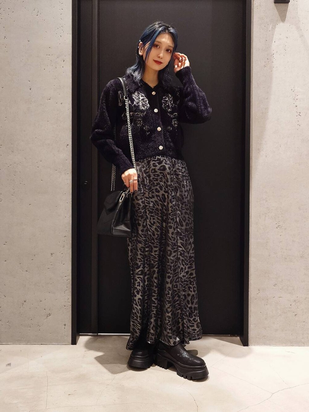 グレー系のトレンチコート、ブラック系のブーツ、ブラック系のショルダーバッグを着用したレディースの冬コーディネートの2枚目の写真