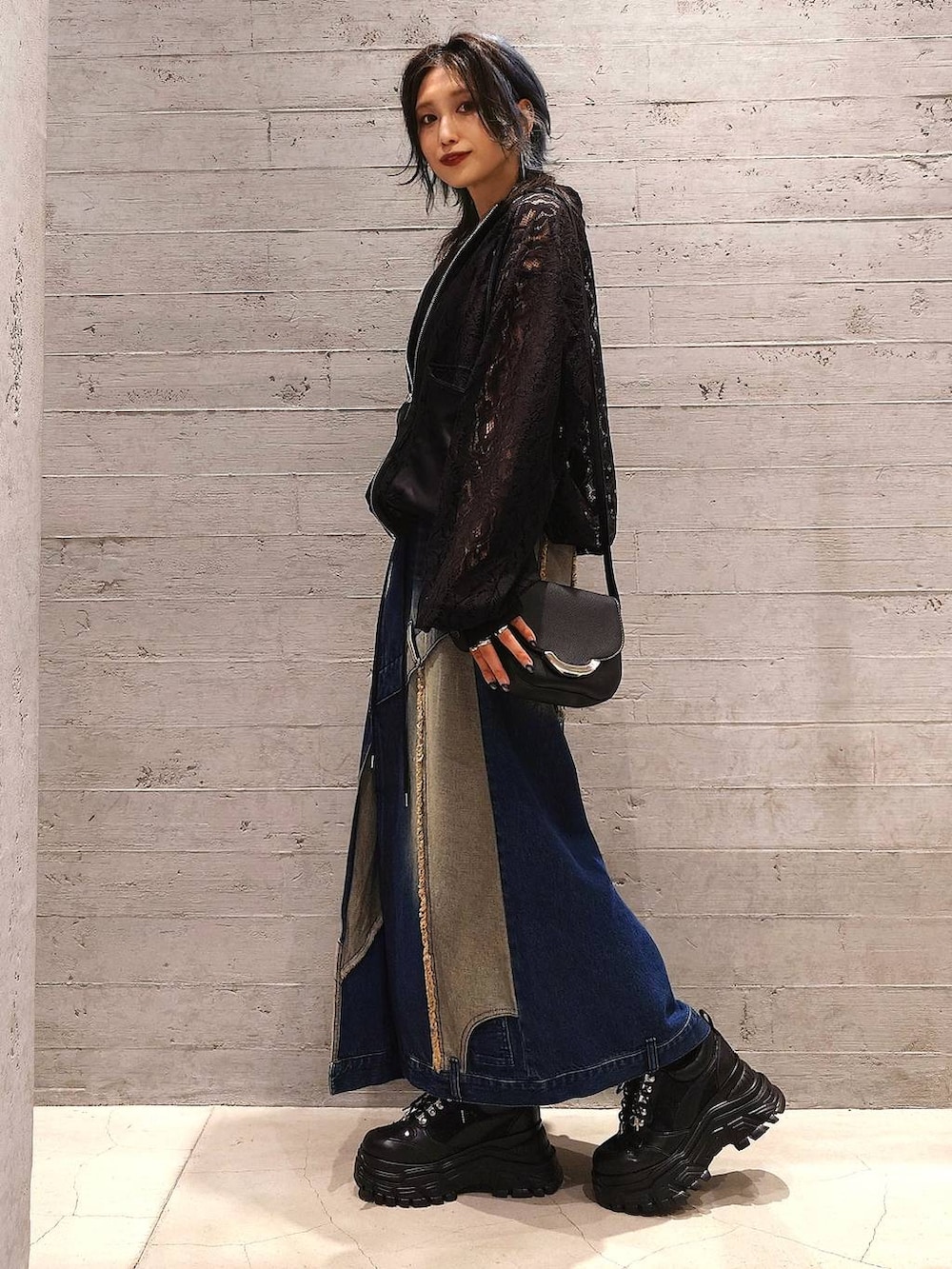 グレー系のタンクトップ、ブラック系のブルゾン、ブルー系のデニムスカートを着用したレディースの夏コーディネートの2枚目の写真