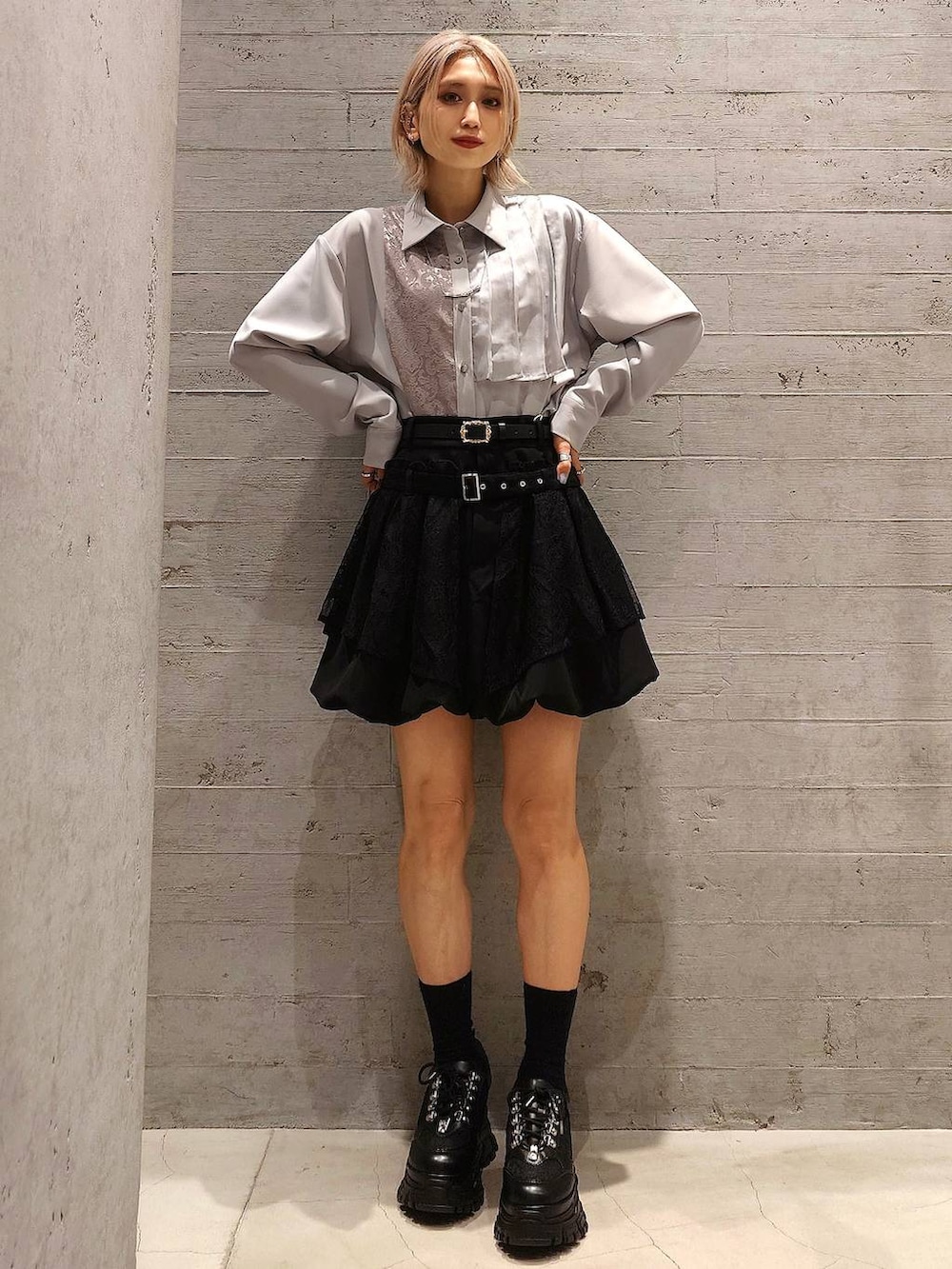 ブラック系のトートバッグ、ブラック系のスニーカー、ブラック系のスカートを着用したレディースの冬コーディネートの2枚目の写真