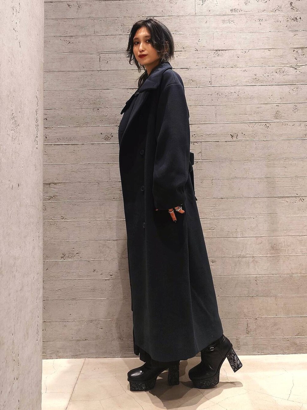 ブラック系のトートバッグ、グリーン系のチェスターコート、グレー系のブーツを着用したレディースの秋コーディネートの2枚目の写真