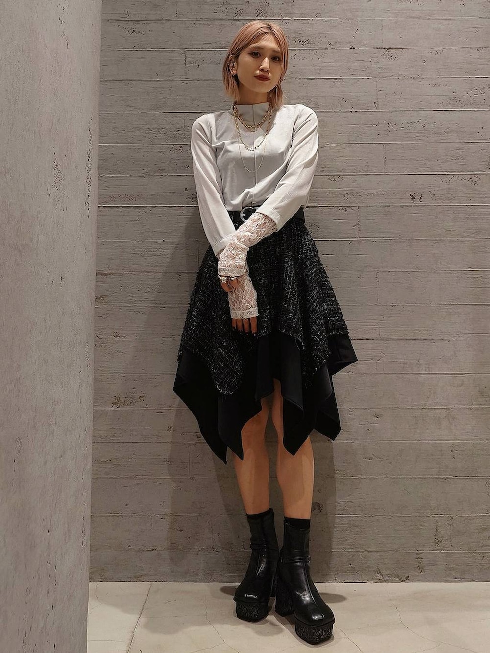 ブラック系のブーツ、ブラック系のボストンバッグ、ホワイト系のTシャツ/カットソーを着用したレディースの冬コーディネートの2枚目の写真