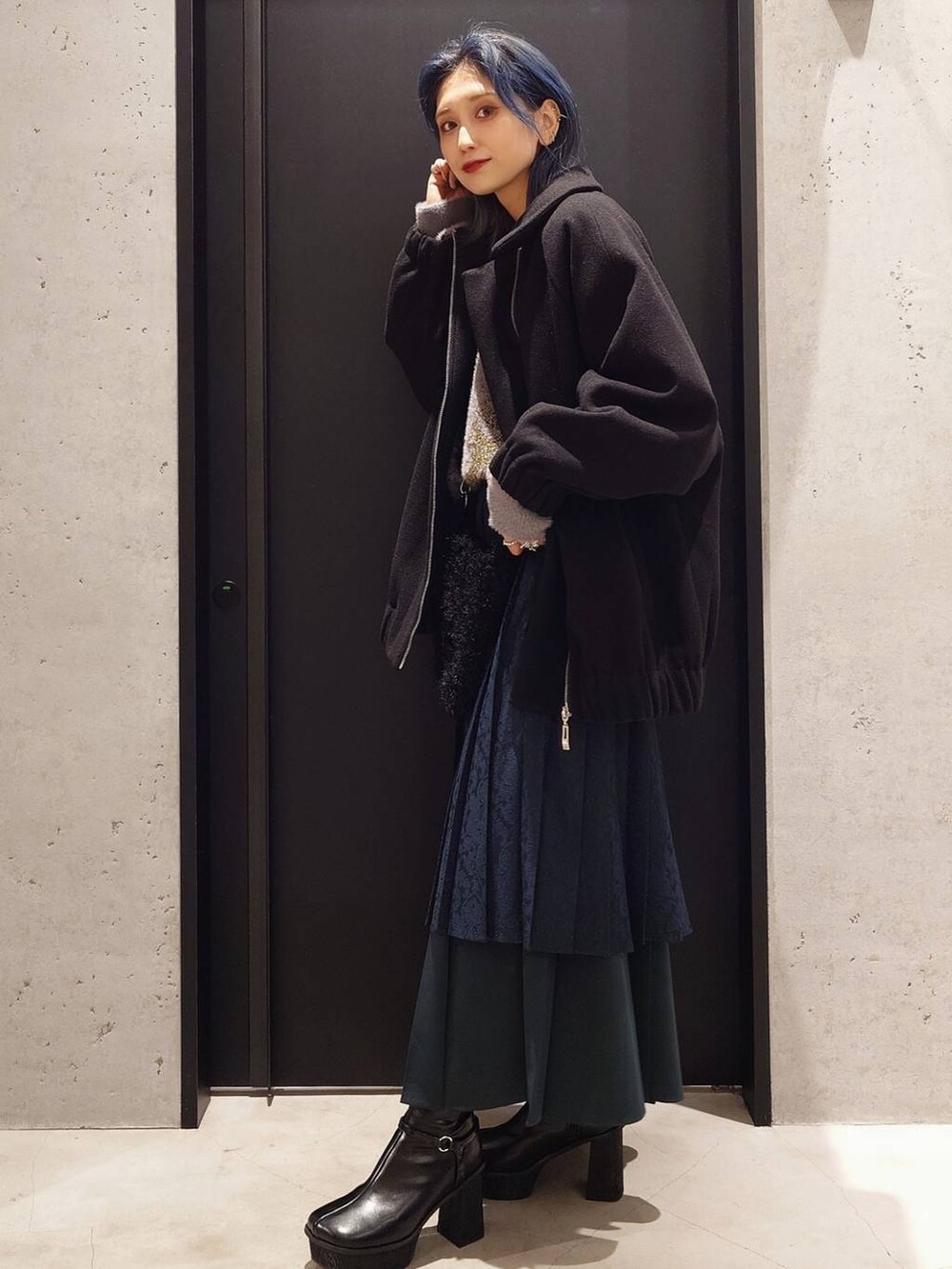 ブラック系のブルゾン、グリーン系のスカート、ブラック系のブーツを着用したレディースの秋コーディネートの3枚目の写真