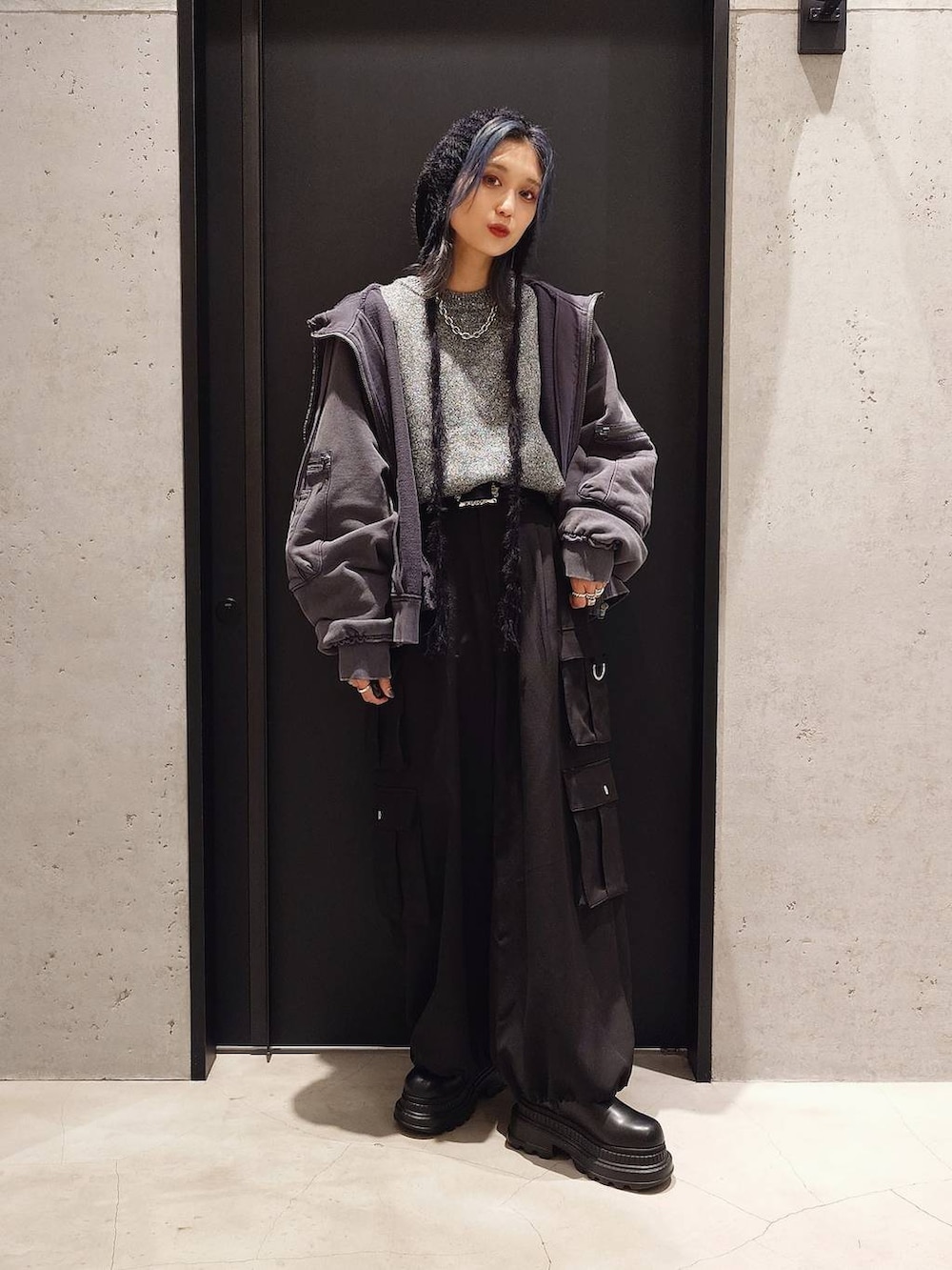 グレー系のパーカー、ブラック系のカーゴパンツ、グレー系のニット/セーターを着用したレディースの秋コーディネートの3枚目の写真