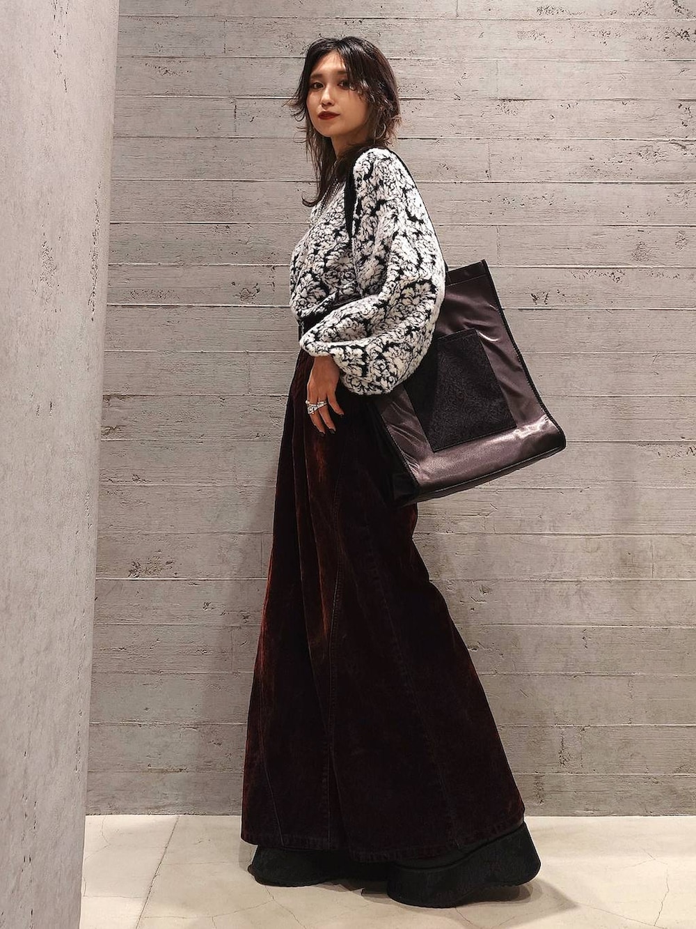 ブラック系のトートバッグ、ブラック系のチェスターコート、ブラック系のニット/セーターを着用したレディースの秋コーディネートの3枚目の写真