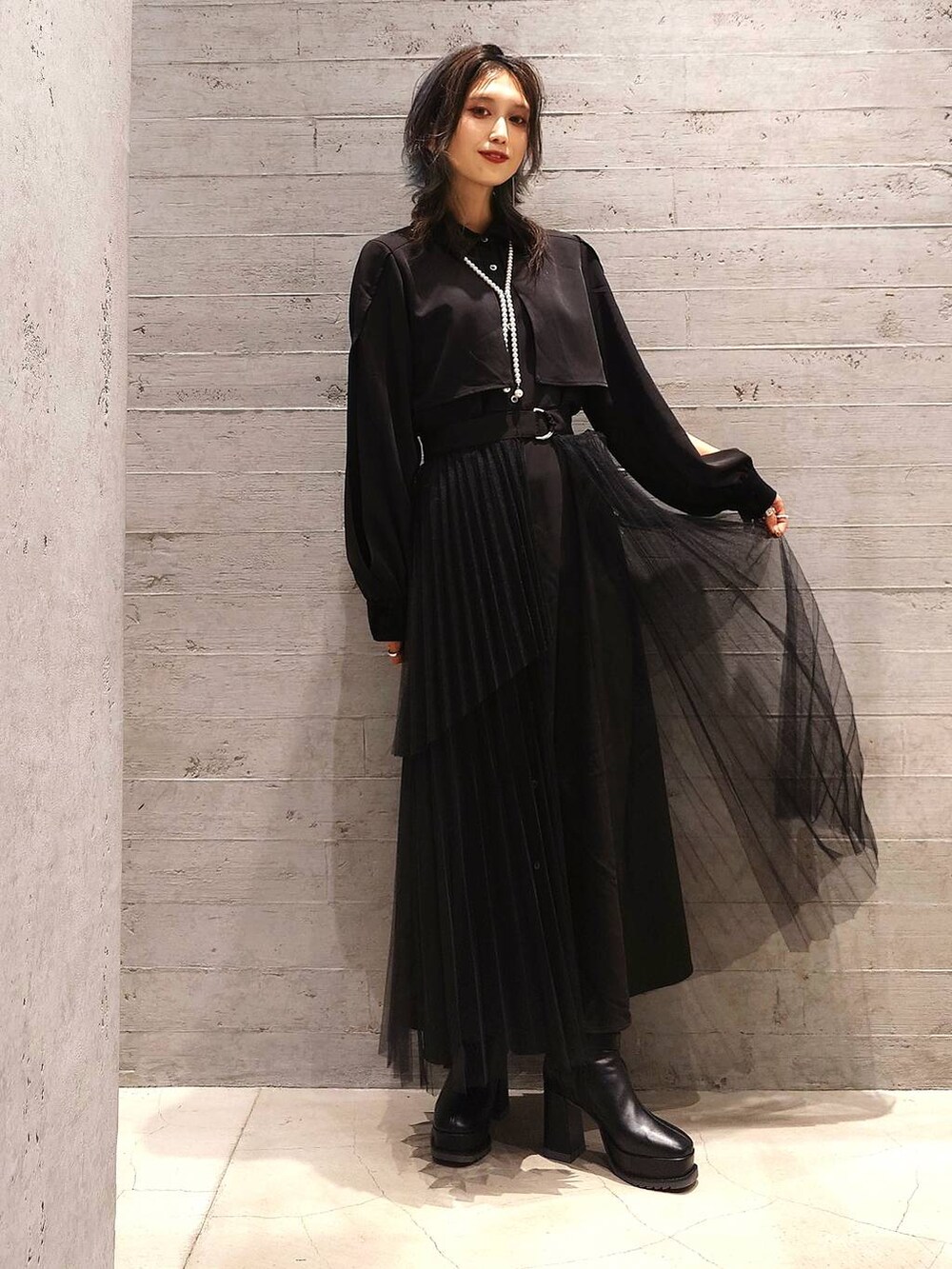 ブラック系のブーツ、グレー系のトレンチコート、ブラック系のワンピースを着用したレディースの秋コーディネートの2枚目の写真