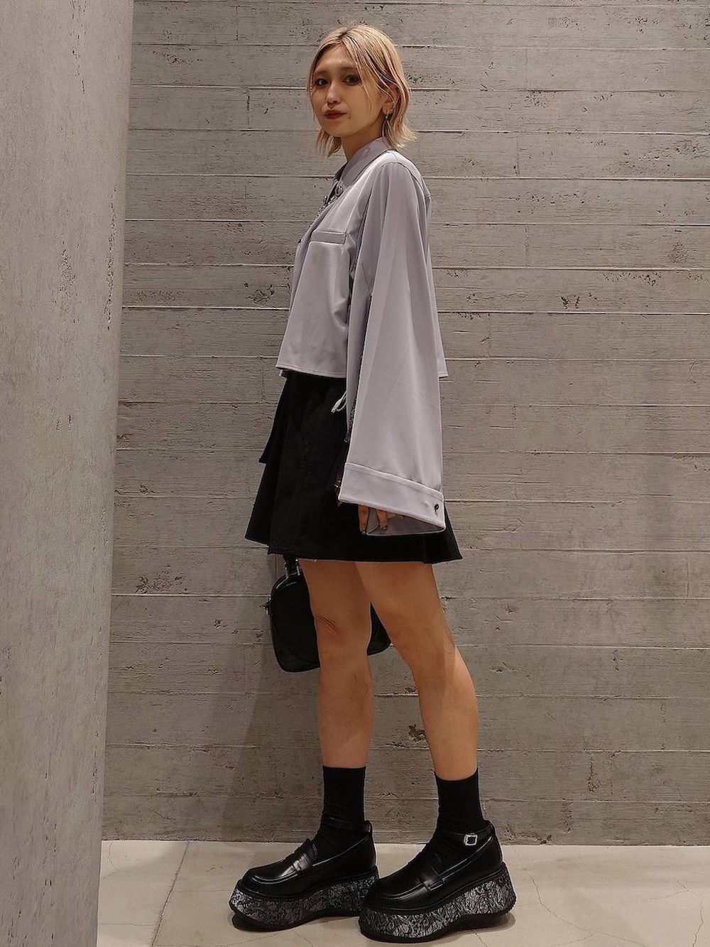 ブラック系のスカート、ブラック系のTシャツ/カットソー、グレー系のローファーを着用したレディースの春コーディネートの2枚目の写真