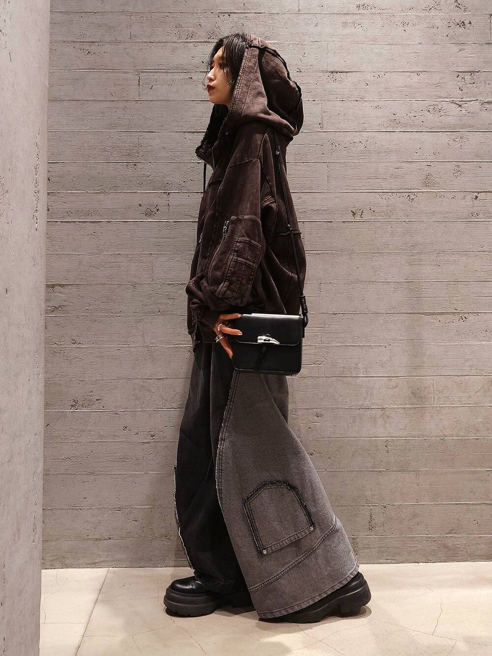 ブラック系のデニムパンツ、ブラック系のショルダーバッグ、ブラック系のTシャツ/カットソーを着用したレディースの秋コーディネートの2枚目の写真