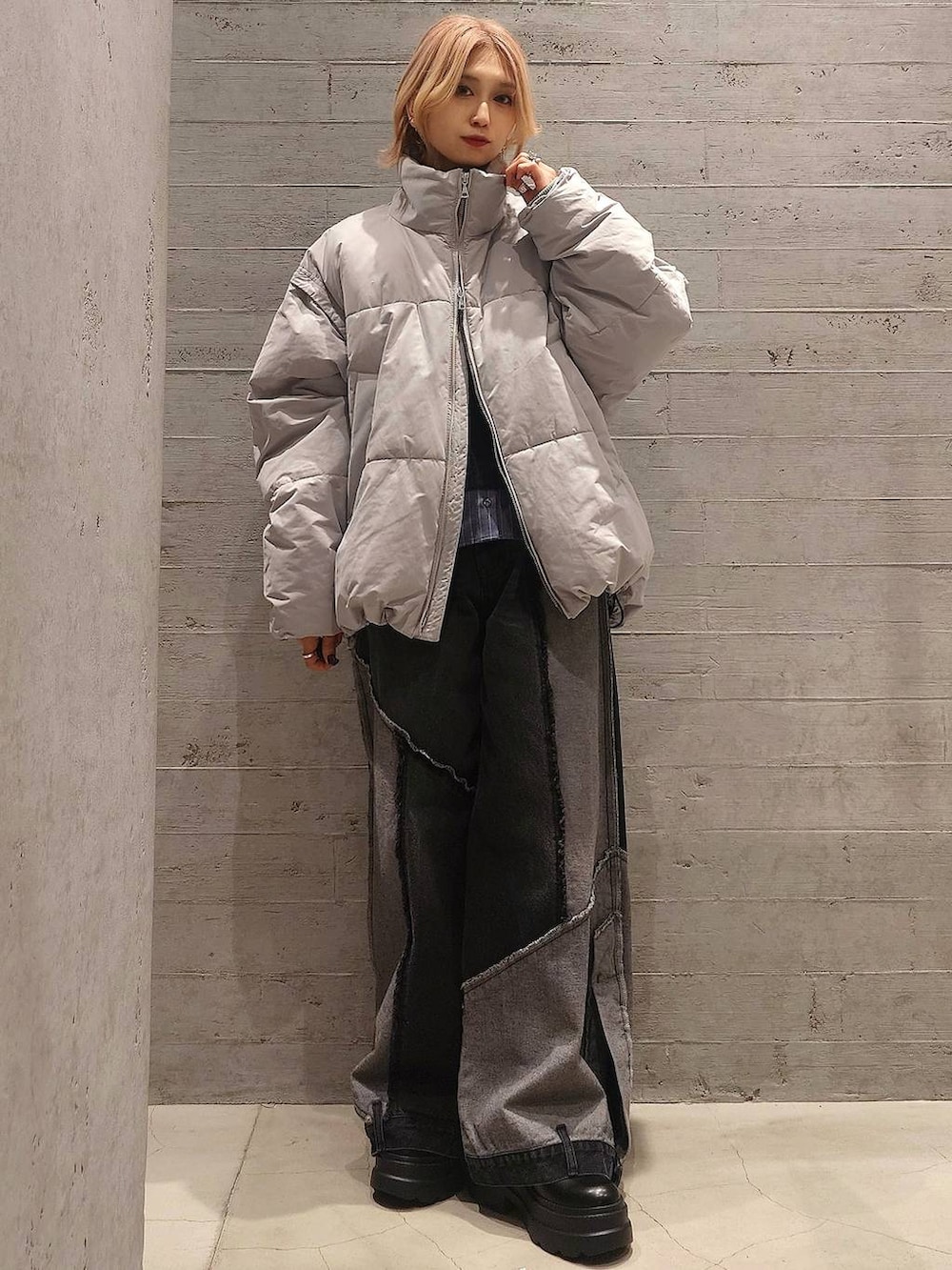 グレー系のダウンジャケット/コート、ブラック系のニット/セーター、ブラック系のデニムパンツを着用したレディースの冬コーディネートの3枚目の写真