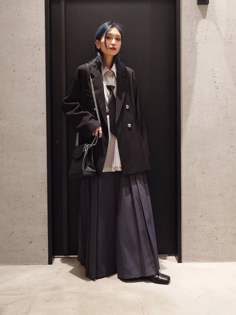 ブラック系のネクタイ、ブラック系のブーツ、グレー系のその他パンツを着用したレディースの冬コーディネートの2枚目の写真