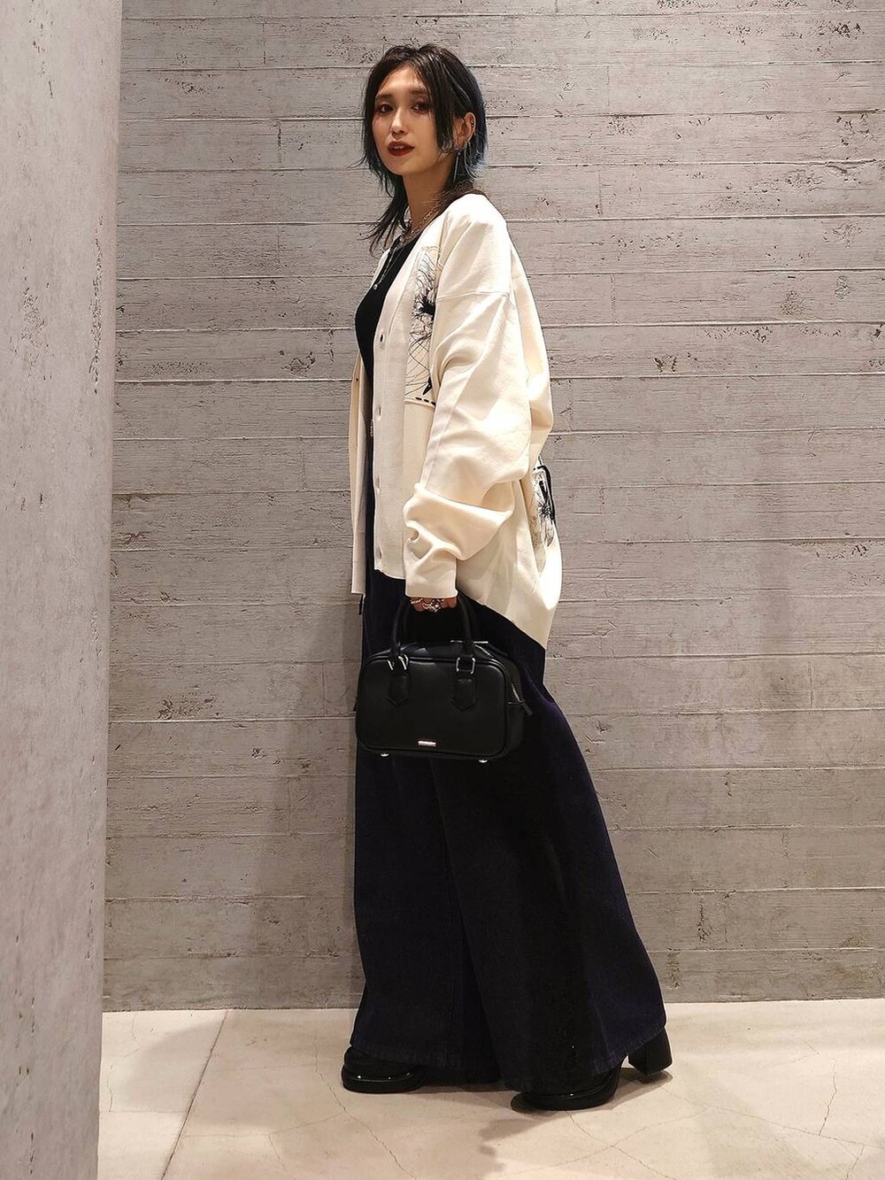 ブラック系のTシャツ/カットソー、ブルー系のデニムパンツ、ブラック系のローファーを着用したレディースの夏コーディネートの2枚目の写真