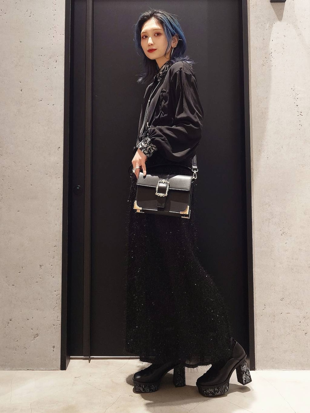 ブラック系のシャツ/ブラウス、ホワイト系のカーディガン/ボレロ、ブラック系のショルダーバッグを着用したレディースの冬コーディネートの3枚目の写真