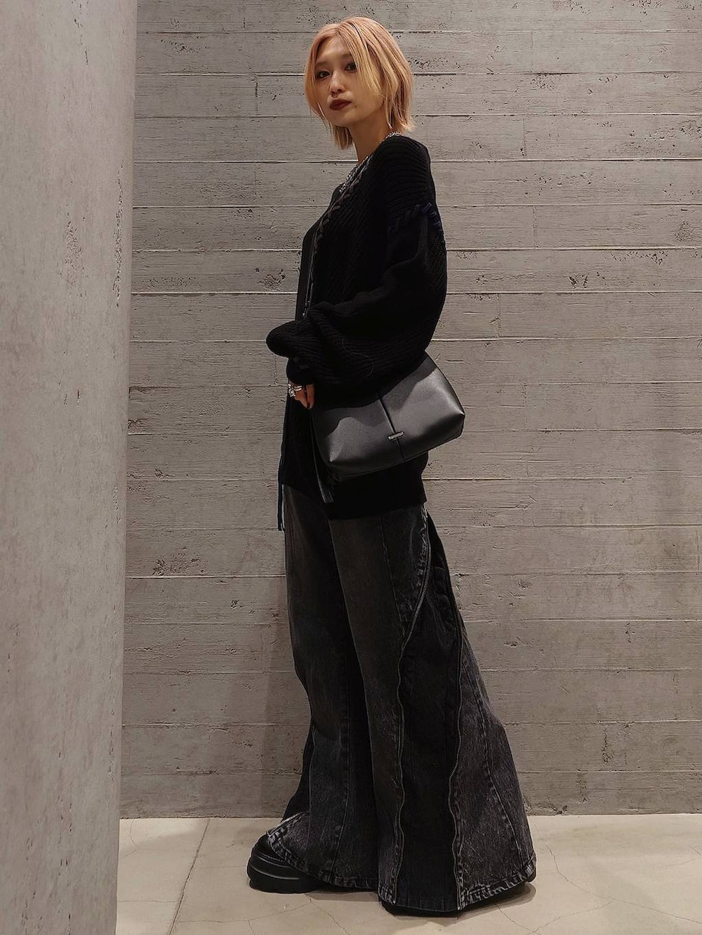 ブラック系のニット/セーター、ブラック系のブーツ、ブラック系のショルダーバッグを着用したレディースの冬コーディネートの2枚目の写真